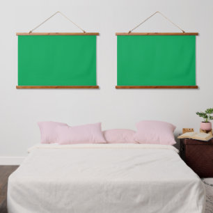 A green screen positioned against a white backgrou hanging tapestry