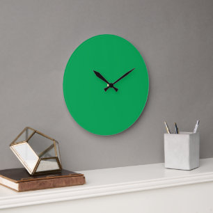 A green screen positioned against a white backgrou large clock