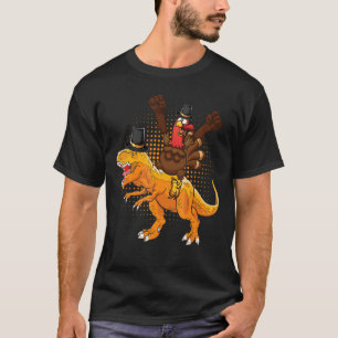 A happy turkey riding a dinosaur they wear hat tha T-Shirt