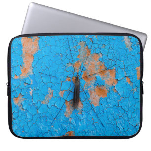 A large mosquito sits on an blue old cracked walla laptop sleeve