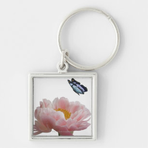 a large pink peony is visited by a ethereal key ring