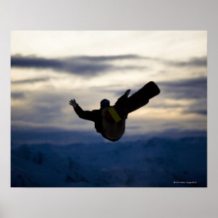 A male snowboarder does a back flip while riding poster