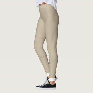 a man in a suit and tie standing in front of a wal leggings