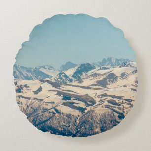 A mountain range with thawing snow and ice in the  round cushion