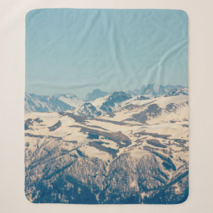 A mountain range with thawing snow and ice in the sherpa blanket