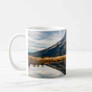 A mountaineer with an orange dress in a symmetric coffee mug