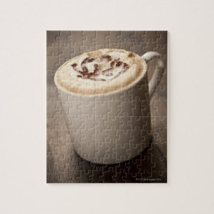 A mug of Cappuccino coffee topped with melted Jigsaw Puzzle
