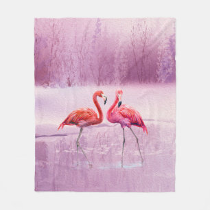 A pair of pink flamingos stand in the water on the fleece blanket