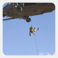 A pararescueman rappels from an HH-60