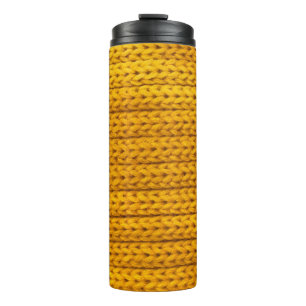 A pattern of yellow knitted fabric of yarn. thermal tumbler