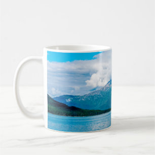 A peninsula of land covered in pine forest juts ou coffee mug