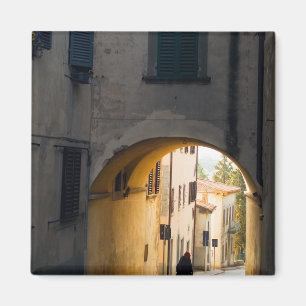 A person walking under an arch, down a hill in magnet