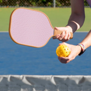 a pink and white background with wavy lines pickleball paddle