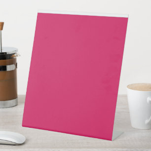 a pink background with a white border pedestal sign