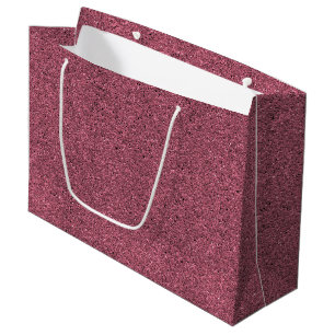 A pink glitter gift bag with a white handle