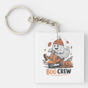 A playful ghost riding a scooter key ring