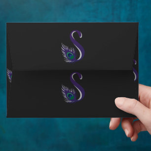 a purple and green peacock feather on a black back envelope