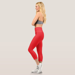 a red background with a white border capri leggings