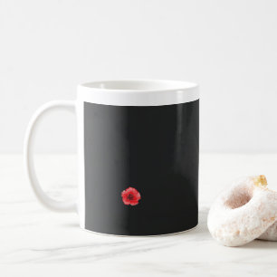 a red flower with a black centre on a black backgr coffee mug