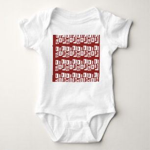 A red rug with a textured pattern is spread out on baby bodysuit