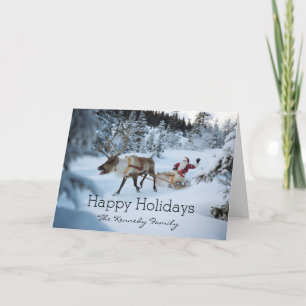 A reindeer pulling Santa Claus and his sleigh Holiday Card