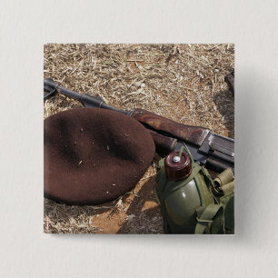 A rifle, military cover and canteen 15 cm square badge