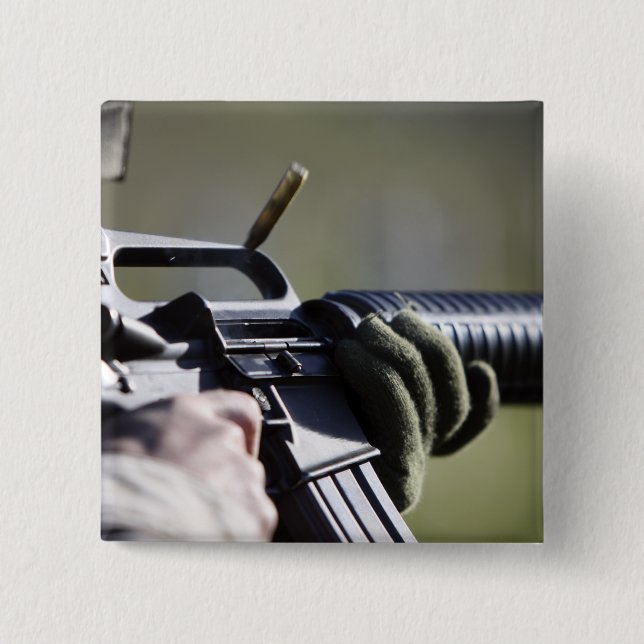 A round flies from the chamber of an M-16A2 15 Cm Square Badge (Front)