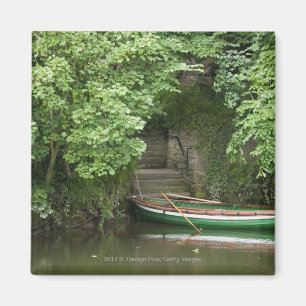 A Row Boat Roped At Some Stairs Along The Shore Magnet