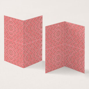 A rug with a red and pink motif features a decorat