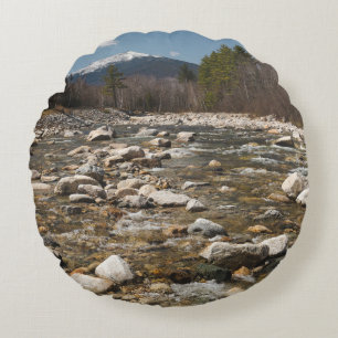 A running stream river with clear water flowing wi round cushion