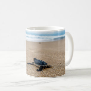 A sea turtle baby aiming at the sea coffee mug