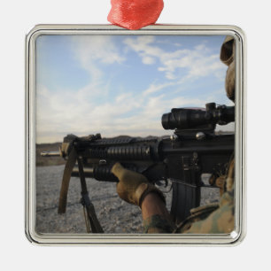 A soldier sights in to fire on a target metal tree decoration