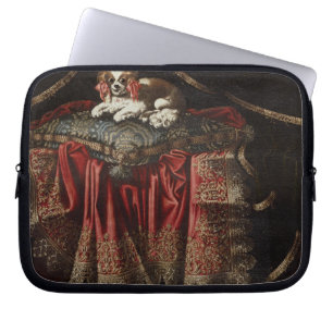 A spaniel seated on an embroidered cushion laptop sleeve