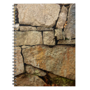 A stone wall made of cobblestones background textu notebook