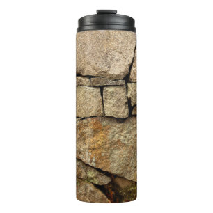 A stone wall made of cobblestones background textu thermal tumbler