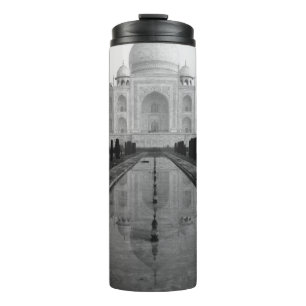 A STREAM OF WATER HEADING TOWARD A LARGE WHITE COL THERMAL TUMBLER