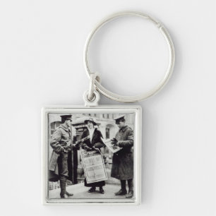 A Suffragette selling newspapers to two Key Ring
