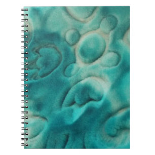 A swirling pattern in teal and light beige notebook