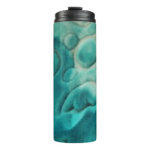 A swirling pattern in teal and light beige thermal tumbler