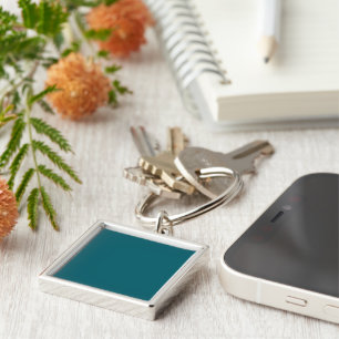A teal blue textured background fills the image key ring