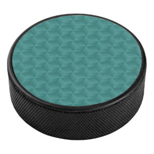 A teal geometric pattern adorns the top  hockey puck