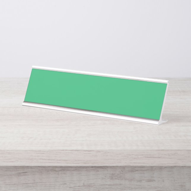 A vibrant green leaf with prominent veins and a de desk name plate (Front)