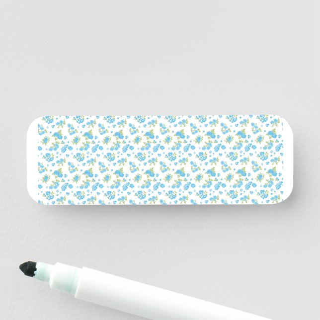 a white background with blue flowers and green lea name tag (In Situ)