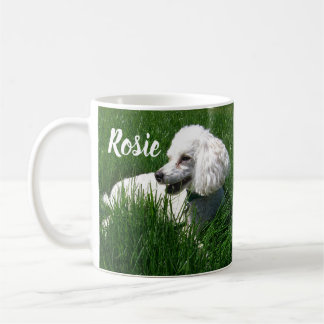 A White Poodle Resting in Lush Green Grass Coffee Mug