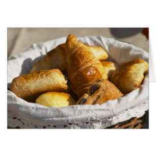 A wicker breakfast basket with croissants, and