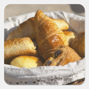 A wicker breakfast basket with croissants, and square sticker