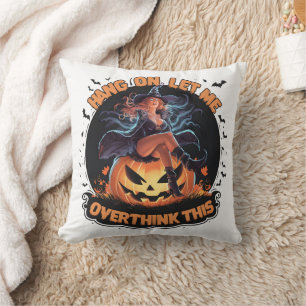 A witch playfully pondering atop a pumpkin cushion