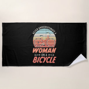 A Woman On A Bicycle Beach Towel