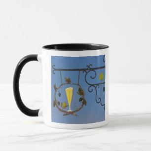 A wrought iron sign that illustrates the theme mug