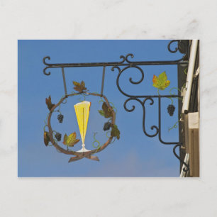A wrought iron sign that illustrates the theme postcard